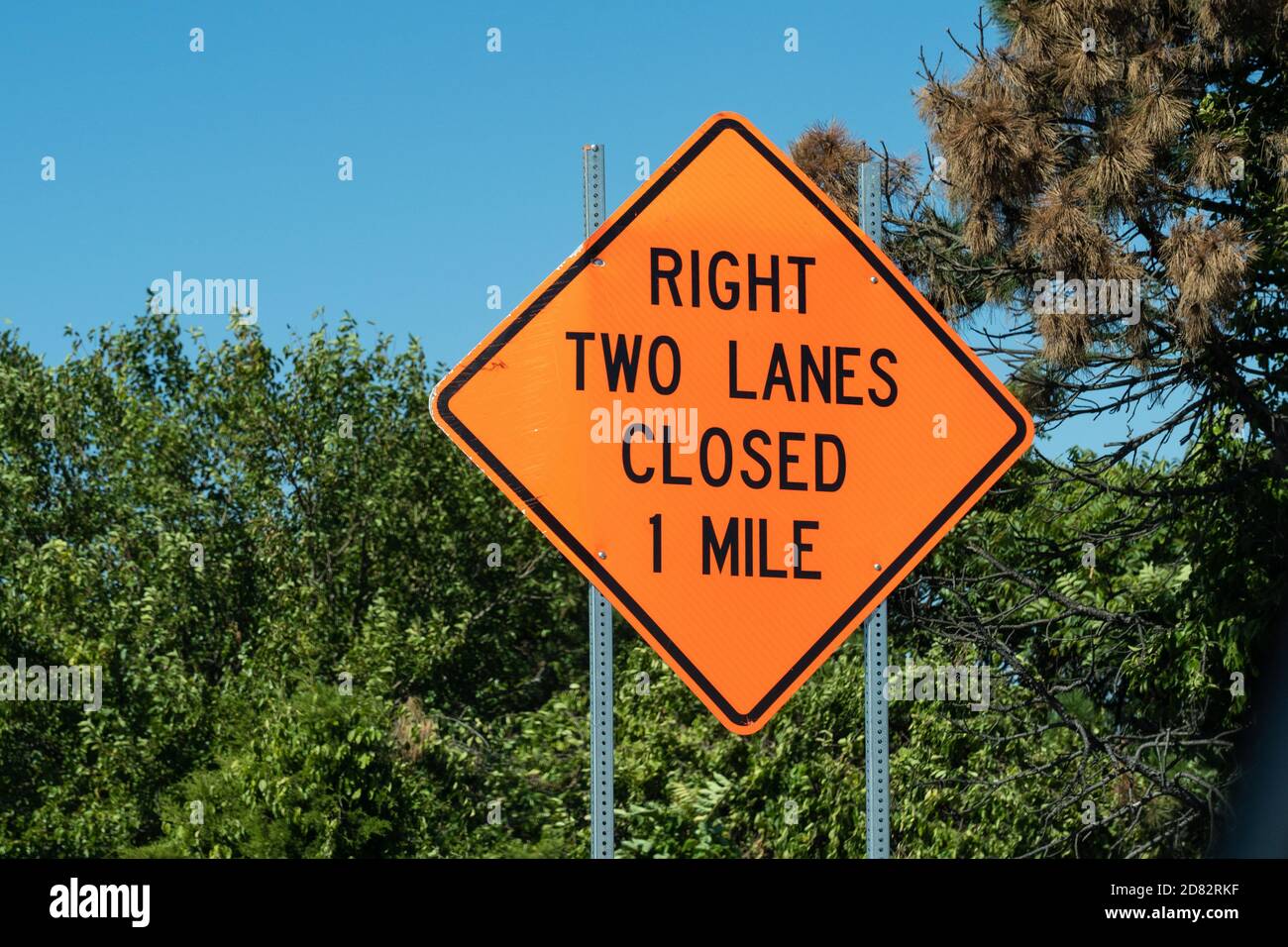 Bright orange Diamond shape sign ways "right two lanes closed 1 mile" on  metal post with Stock Photo - Alamy