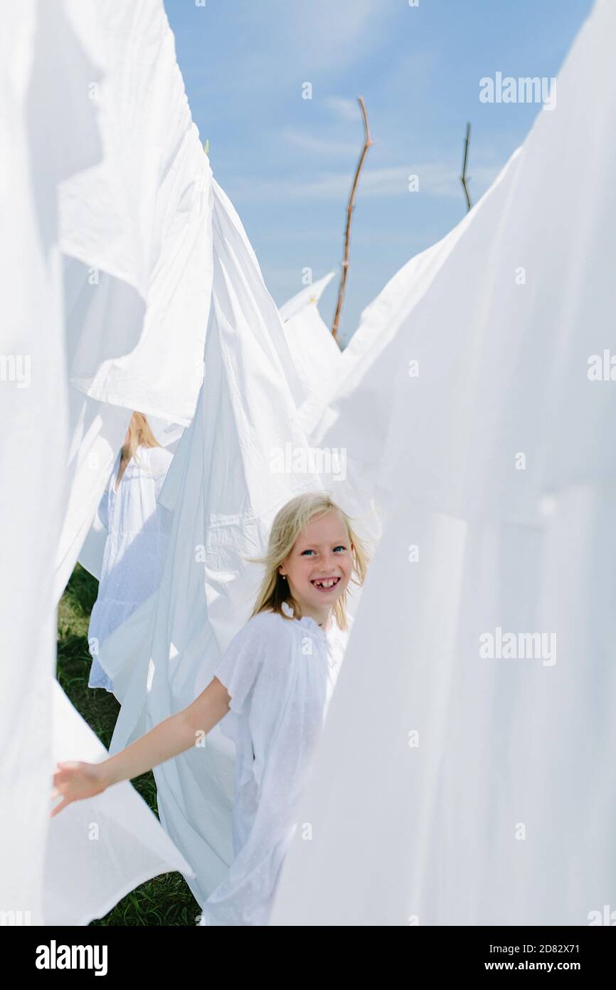 Little blondes in summer play with sheets Stock Photo