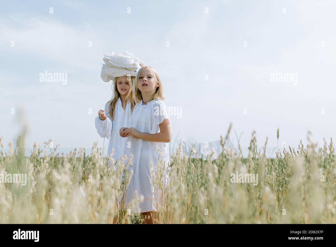 Little blondes in the village carry the washed laundry Stock Photo