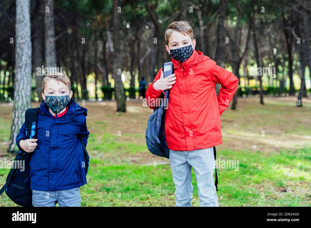 boy putting on his school backpack Stock Photo