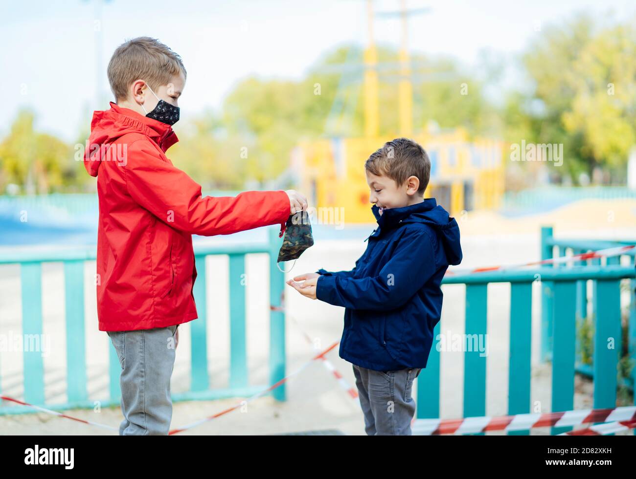 little boy handing a mask to his brother Stock Photo - Alamy