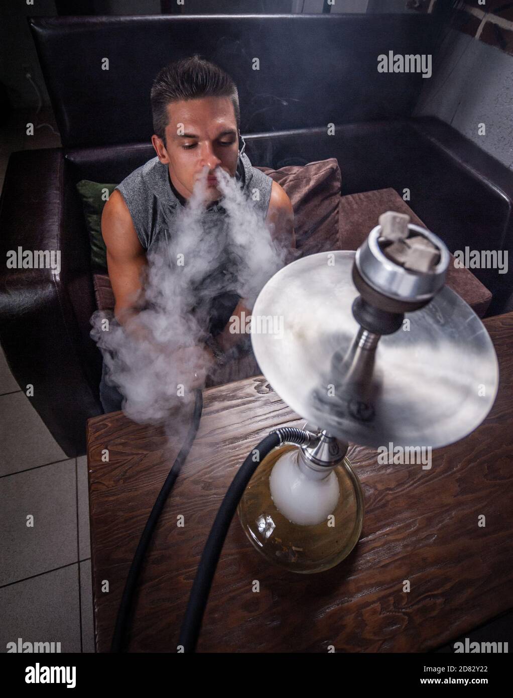 Handsome guy relaxes in a hookah in the shisha bar. Stock Photo