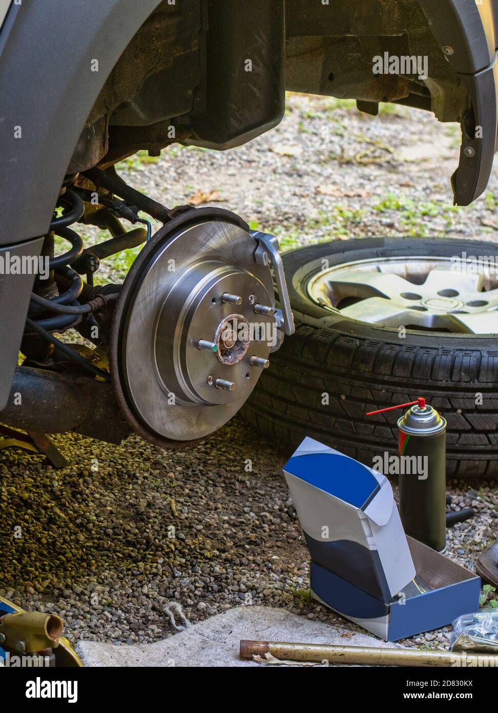 A brake job is being done at home in the drive way to save money Stock