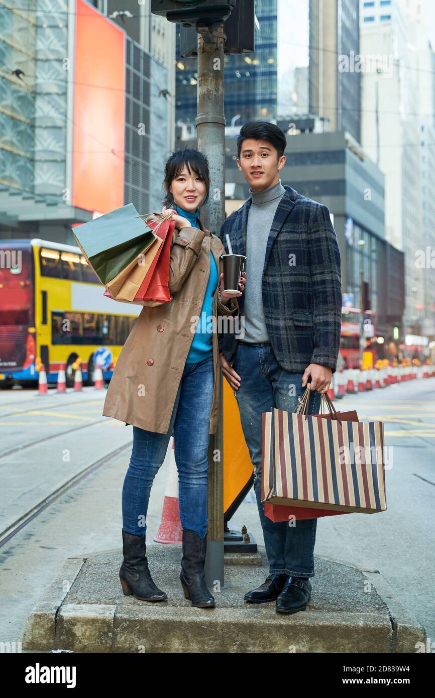 outdoor portrait of a young asian couple with shopping bags in hand Stock Photo