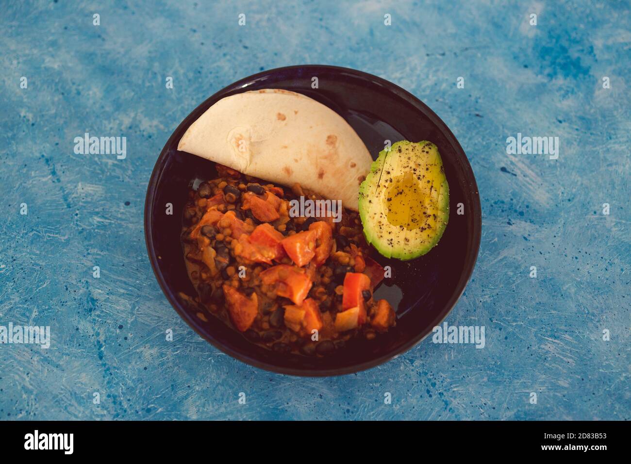 healthy plant-based food recipes concept, vegan mexican bean mix and avocado with mini tortilla bread Stock Photo