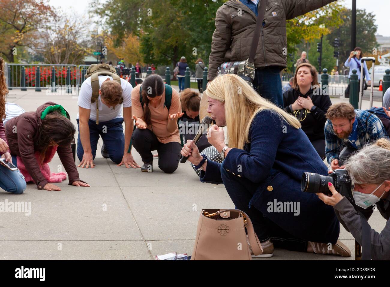Washington, DC, USA, 26 October,  2020.  Pictured: A group of charismatic Christians held a group prayer on the grounds of the Supreme Court.  They knelt, raised arms, appeared to be talking to themselves, all while pushing for Amy Coney Barrett's confirmation.  Credit: Allison C Bailey/Alamy Live News Stock Photo