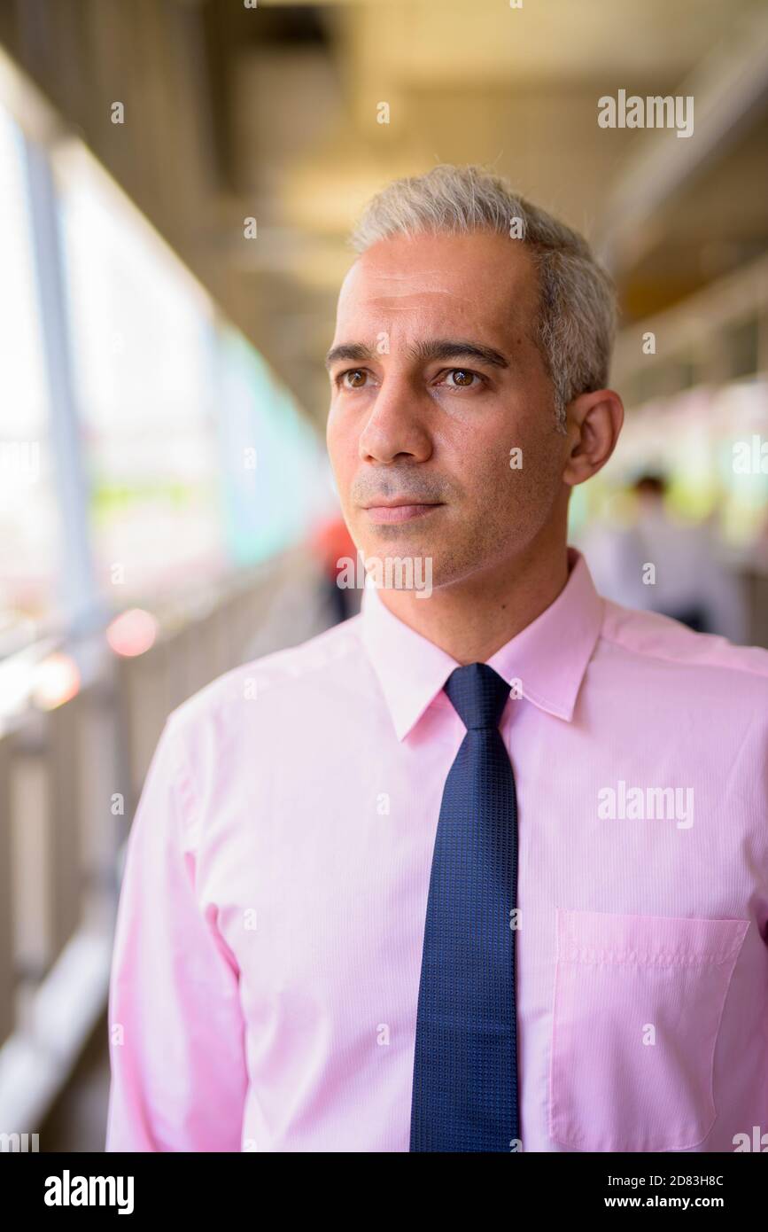 Face of handsome Persian businessman thinking at the footbridge in the ...