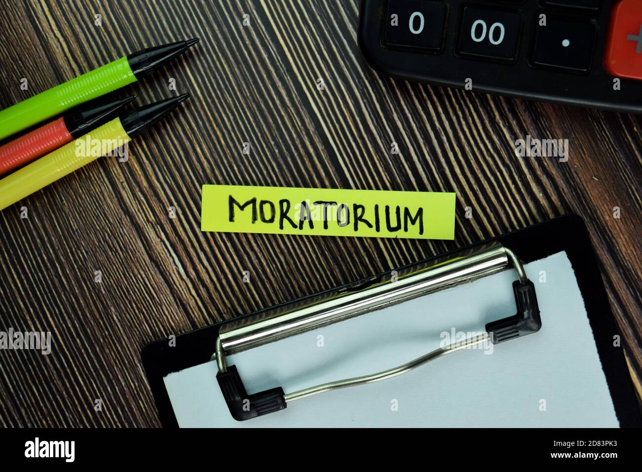 Moratorium write on sticky note and isolated on Wooden Table. Finance Concept Stock Photo