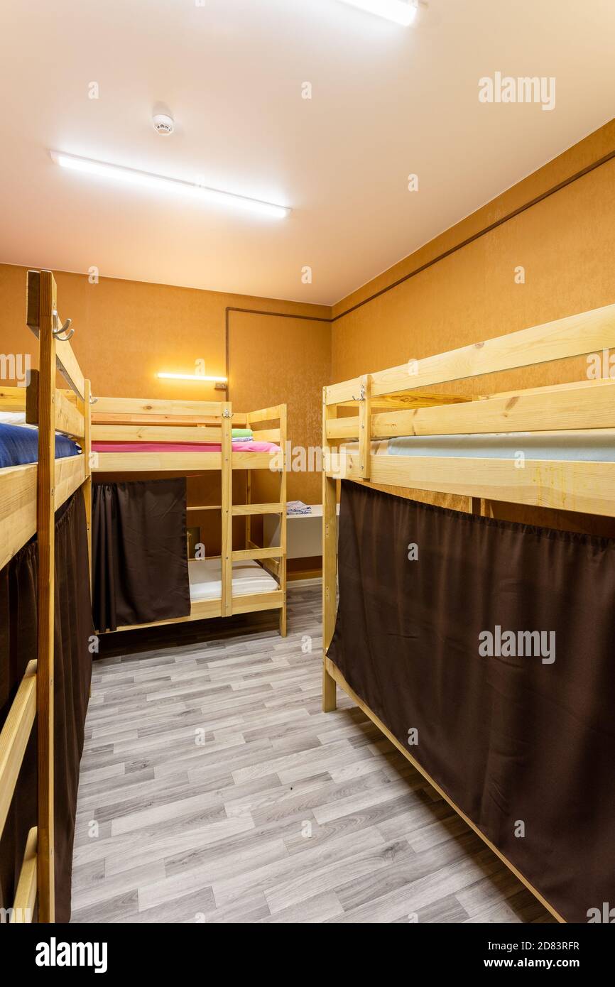 Wooden bunk beds with curtains in a large hostel dorm room Stock Photo -  Alamy