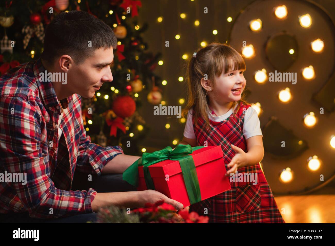 cute Asian daughter girl give her a mother hug after exchanging gifts.  Parent and little child having fun near tree indoors. Merry Christmas and  Happy Stock Photo - Alamy