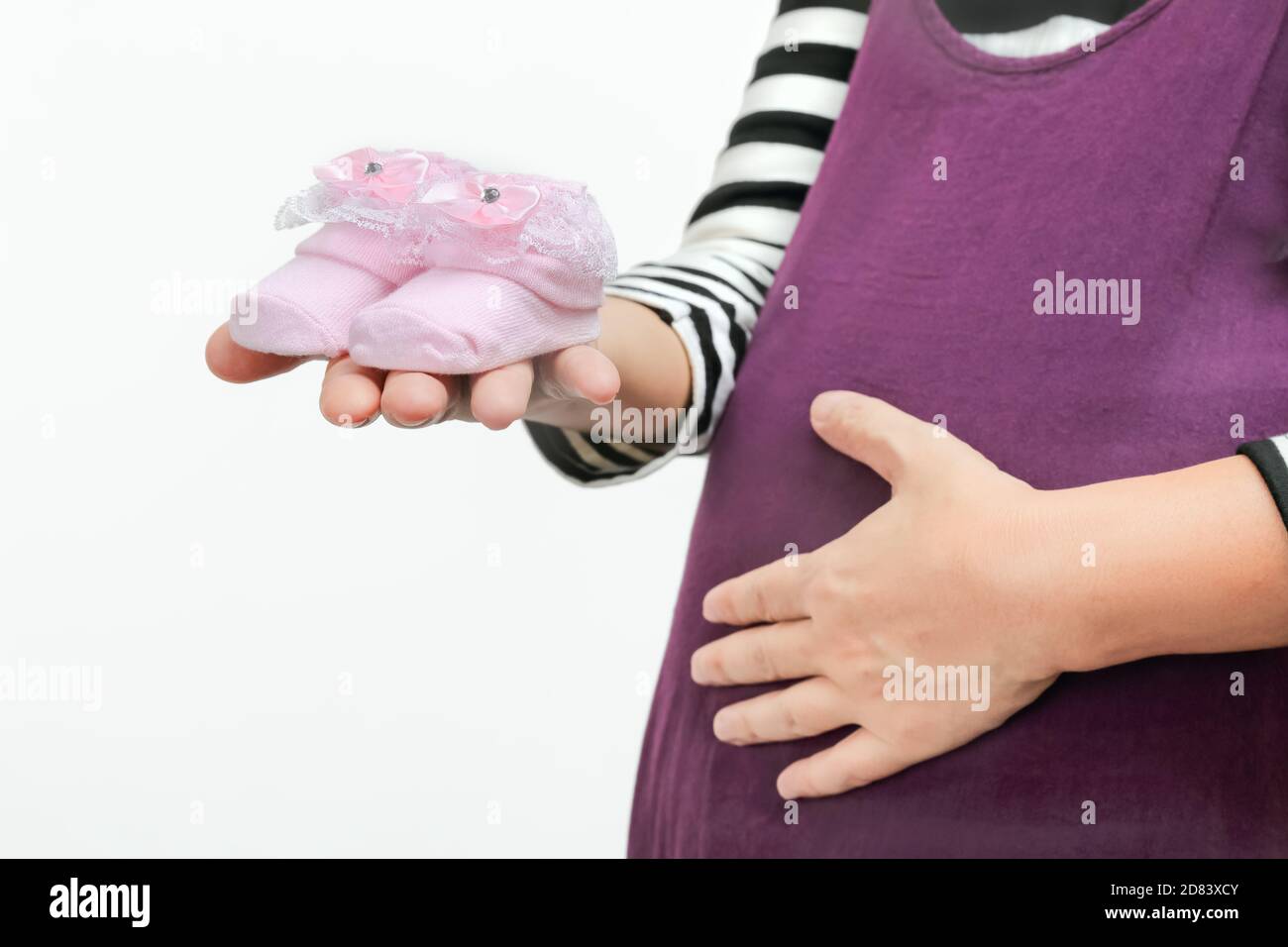 Single mom pregnancy holding baby shoes, close up Stock Photo