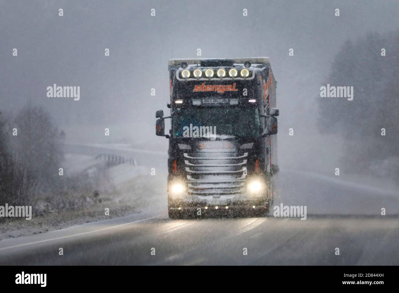 Customised Scania truck of Stengel LT pulls trailer along Finnish national road 52 in winter snowstorm. Salo, Finland. November 29, 2019. Stock Photo