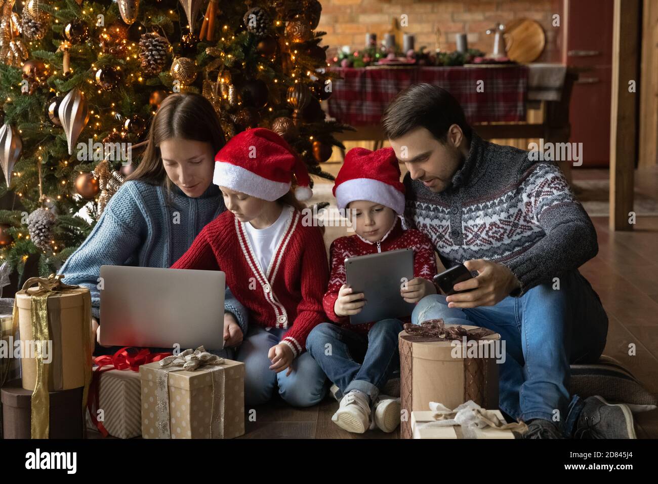 Young family with kids use gadgets on winter holidays Stock Photo