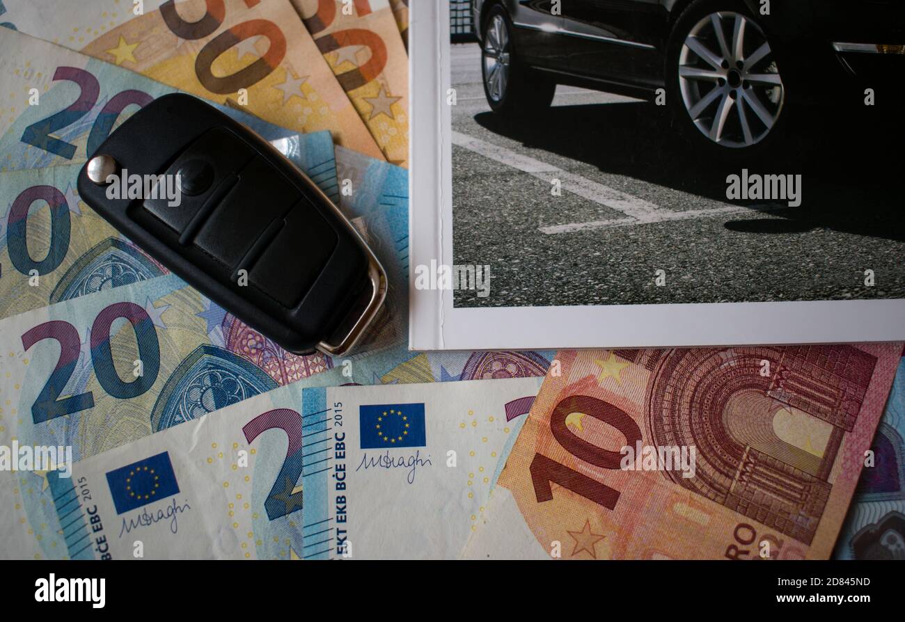 Car key and cut out new car catalog on euro money banknotes Stock Photo