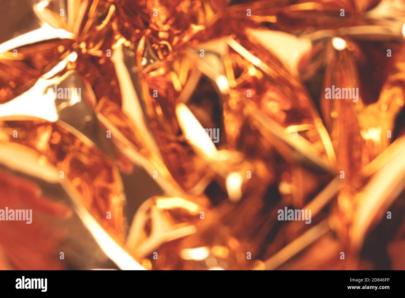Blurred golden foil shiny texture. Defocused background. Stock Photo