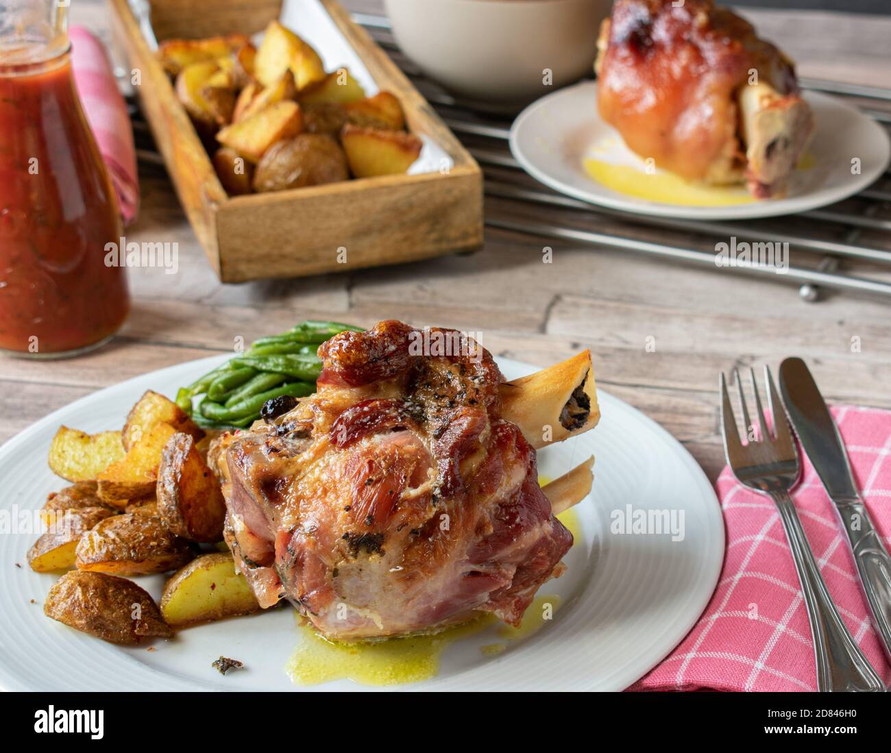 roasted knuckle of pork served with potatoes on a plate Stock Photo