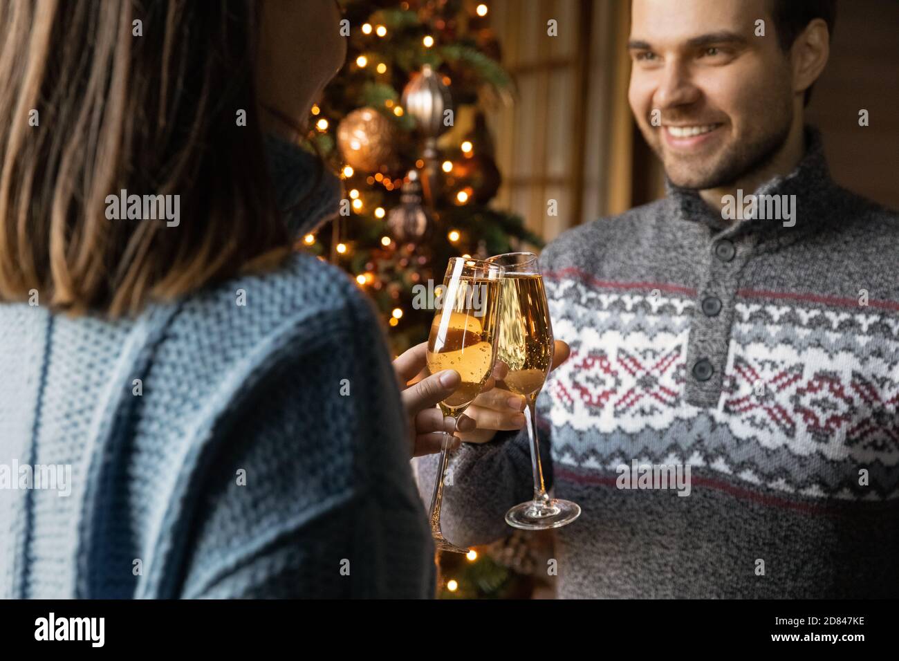 Happy couple clink bottles celebrating New Year Stock Photo