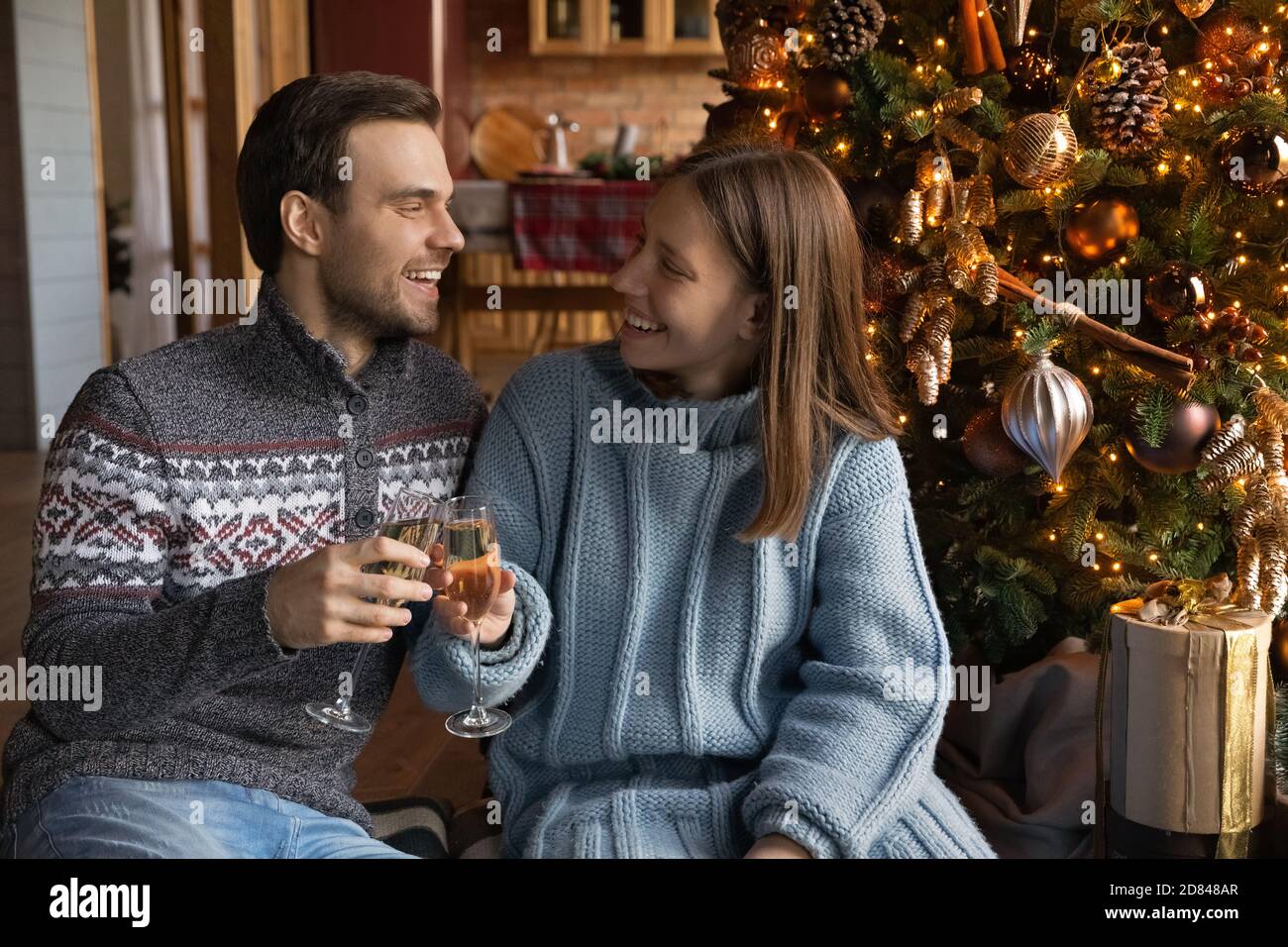 Happy couple celebrate New Year near Christmas tree Stock Photo