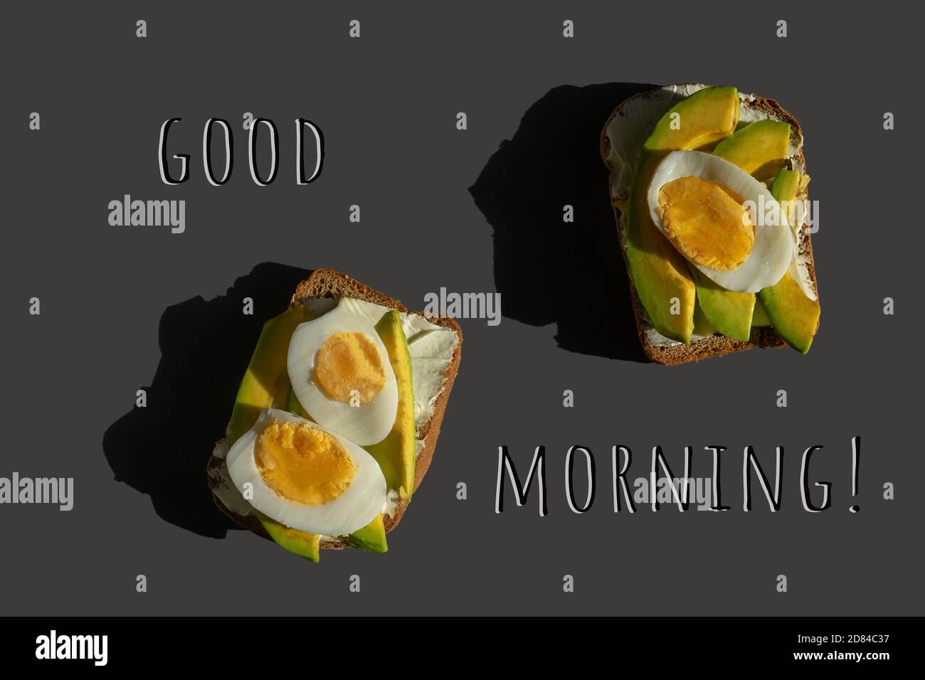 Healthy lunch snack, breakfast. Bright concept from delicious avocado sandwiches made with fresh sliced avocados on gray background, top view. Good mo Stock Photo