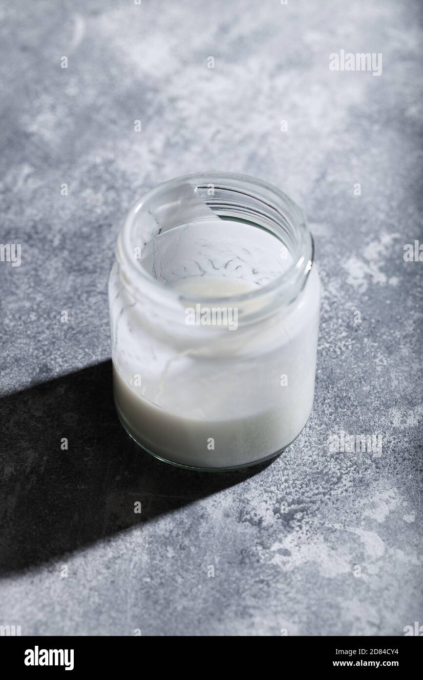 Dairyfree greek yogurt kefir with coconut milk in glass jar on gray