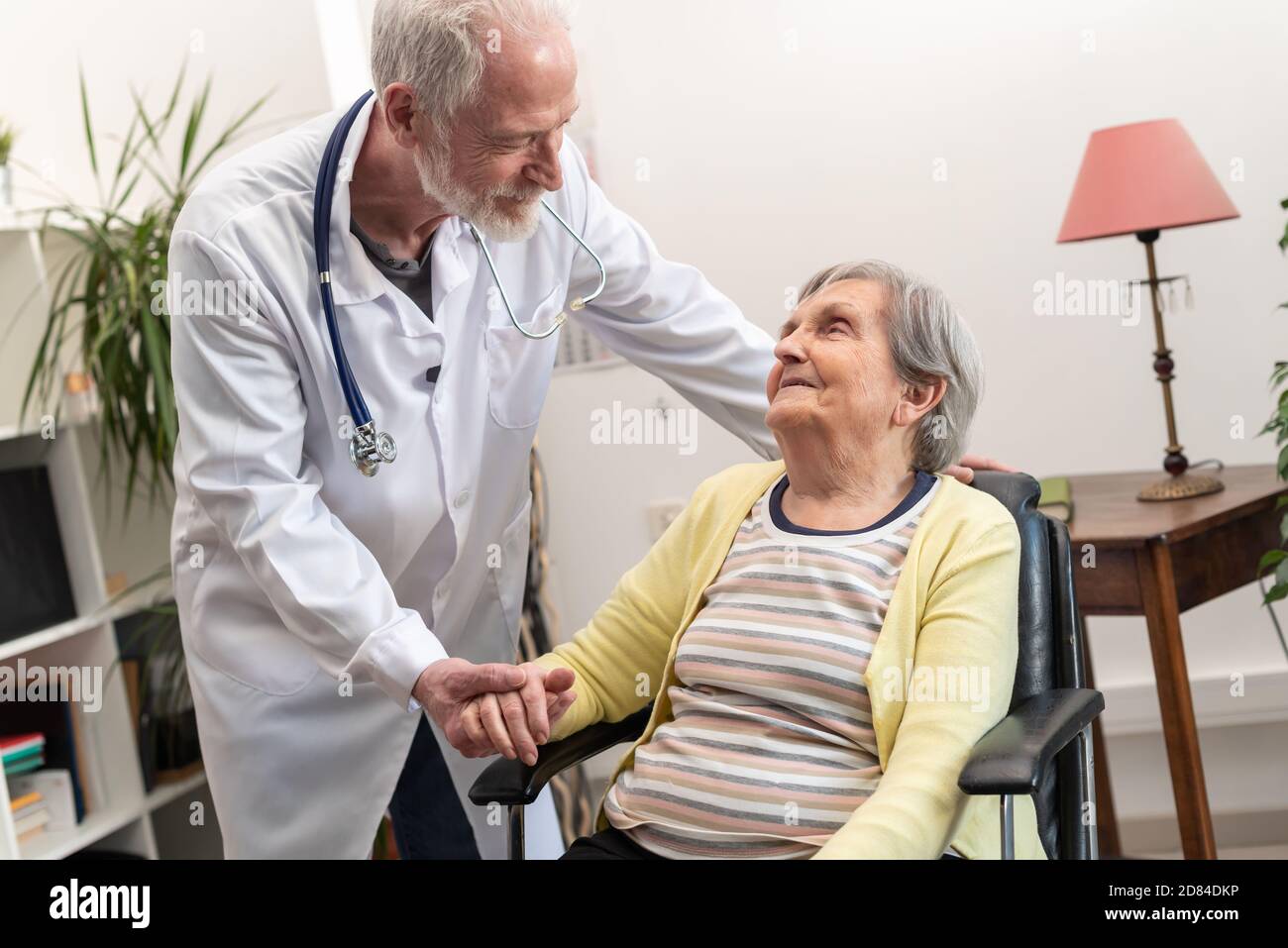 Doctor supporting elderly woman hi-res stock photography and images - Alamy