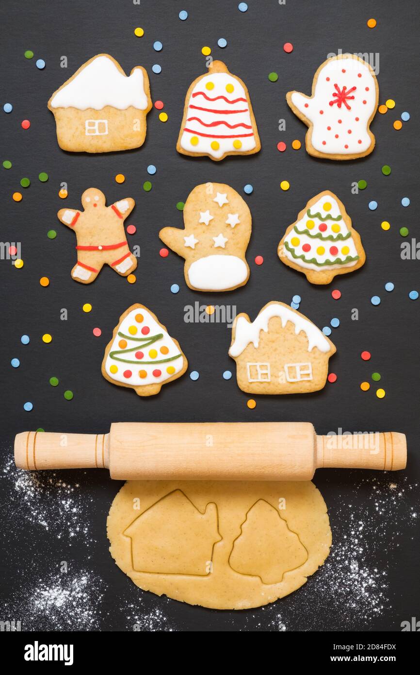 Christmas gingerbread cookies, rolling pin and dough on black