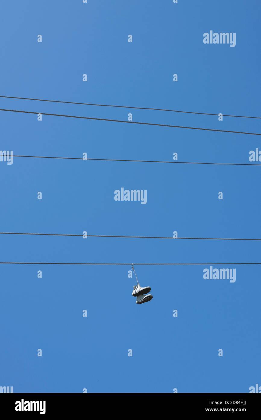 Shoes suspended to power lines. Stock Photo