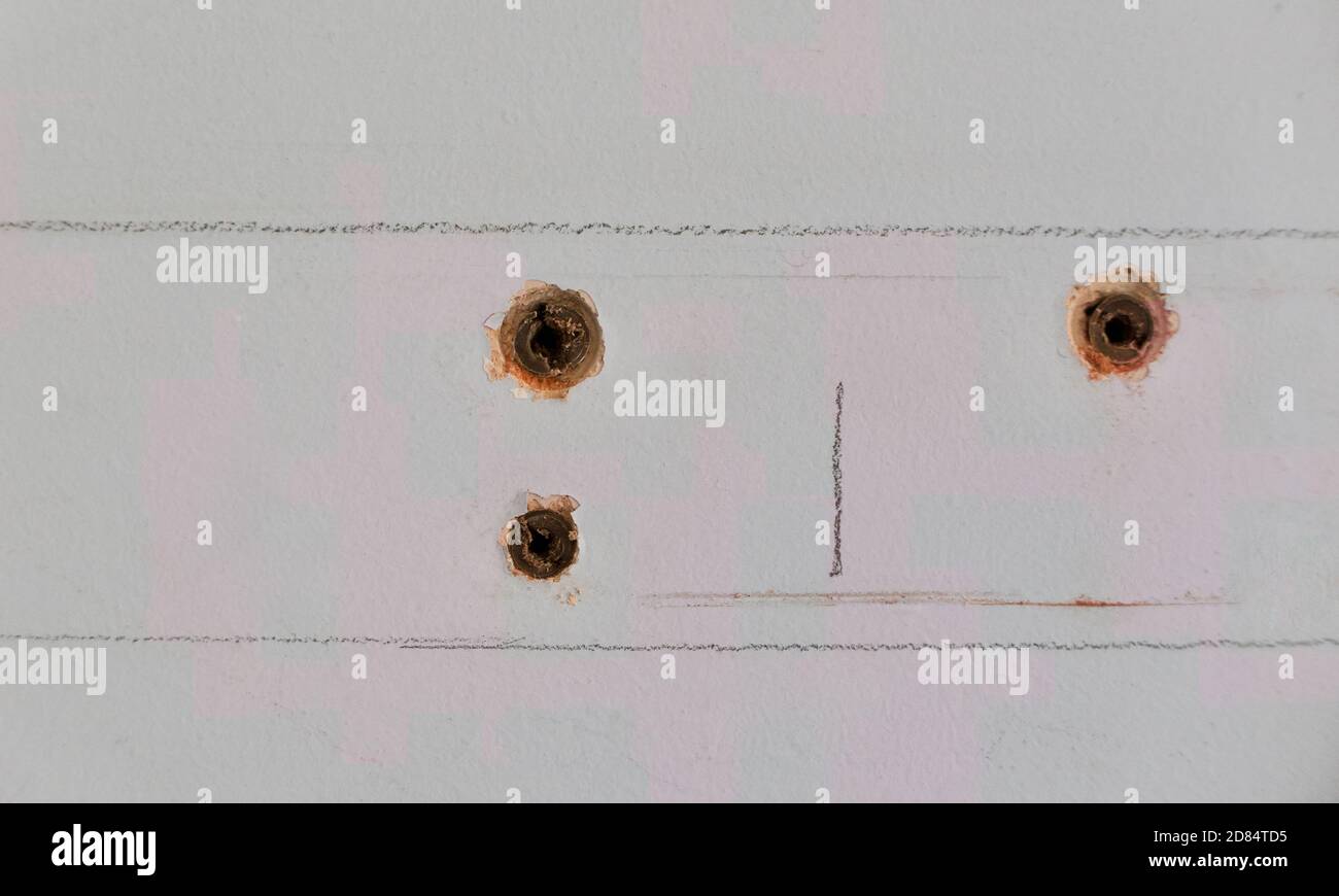 Carpenter's markings on wall with rawl plug holes where screws had been
