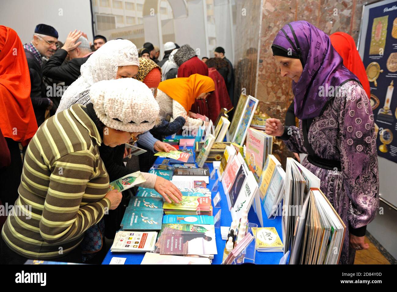 Female muslims buying religious book during celebrating Islamic holiday Mawlid Stock Photo