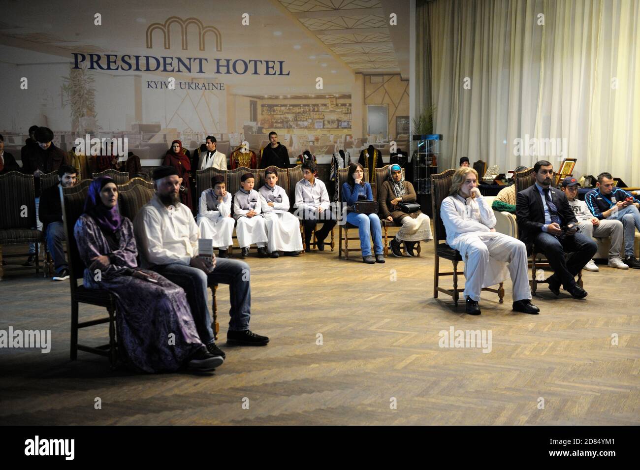 Group of Muslims sitting in conference hall celebrating Islamic holiday Mawlid Stock Photo