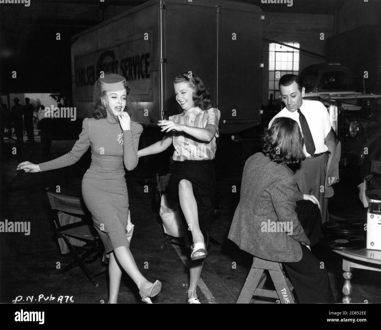 IDA LUPINO and ANN SHERIDAN dance to music on record player with GEORGE RAFT and Film Crew on set candid during filming of night scene for THEY DRIVE BY NIGHT 1940 director RAOUL WALSH associate producer Mark Hellinger executive producer Hal B. Wallis Warner Bros. Stock Photo
