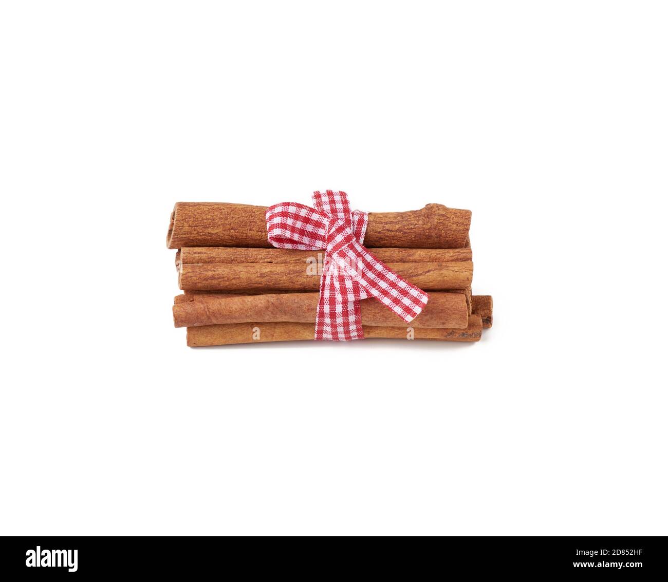 dry cinnamon sticks tied with red ribbon, spice isolated on white background Stock Photo