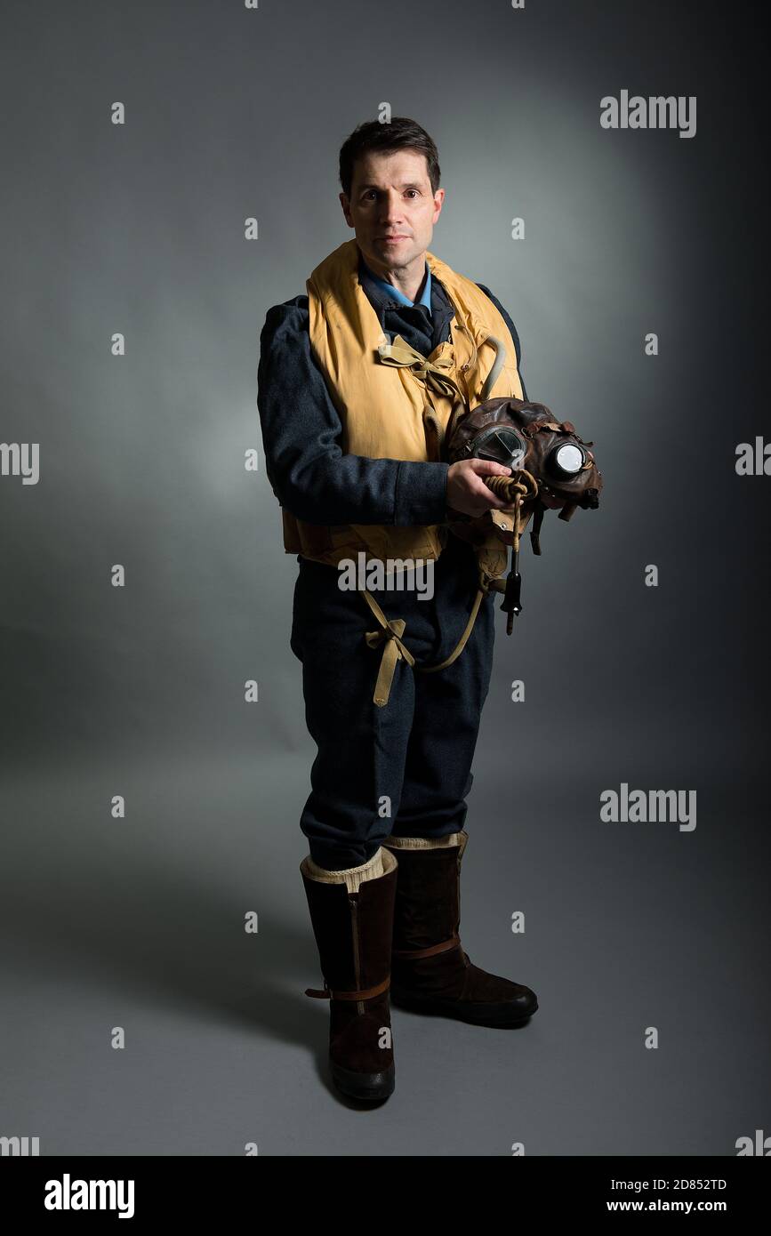 World War Two, RAF fighter pilot / bomber crew member, standing against a grey studio background. Stock Photo