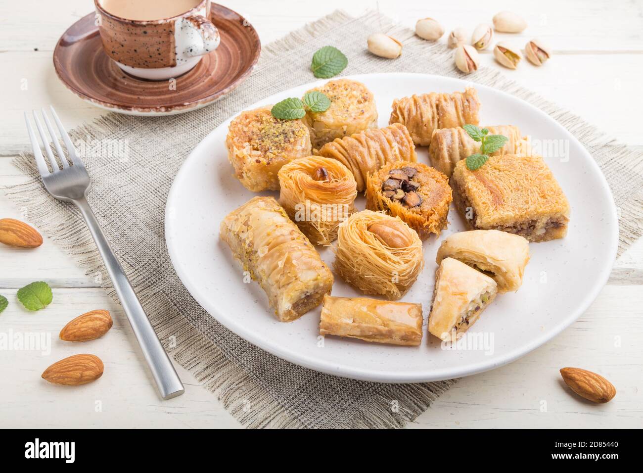 traditional arabic sweets (kunafa, baklava) and a cup of coffee on a ...