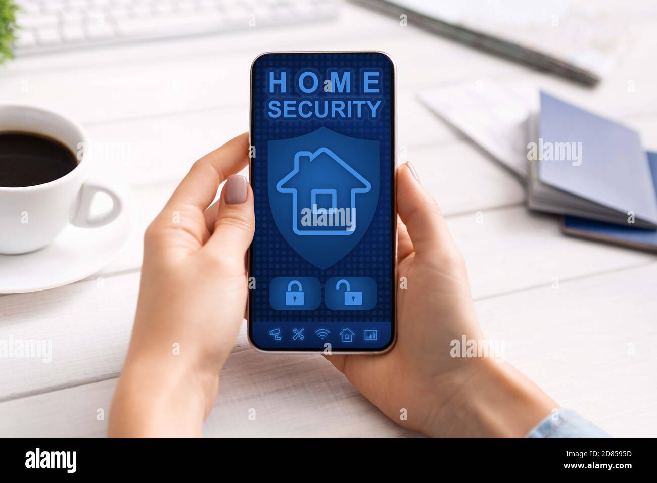 Lady using her smartphone with home security application Stock Photo
