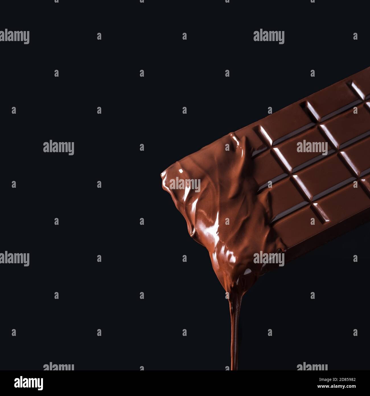 Dripping melted chocolate bar on dark background Stock Photo