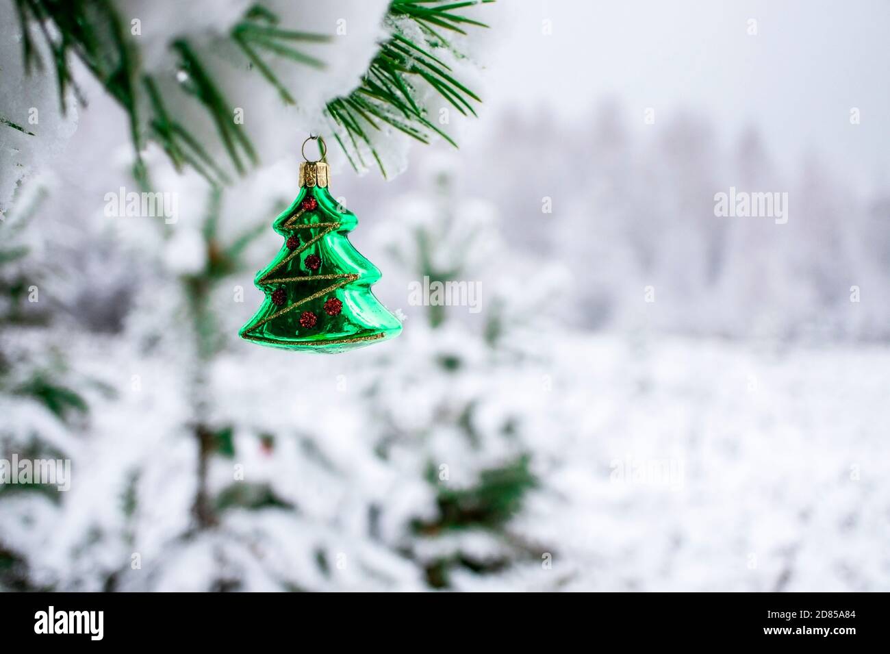 Christmas background with a green Christmas tree toy on a snow-covered pine  branch with a copy space. New year holiday, christmas celebration, greetin  Stock Photo - Alamy