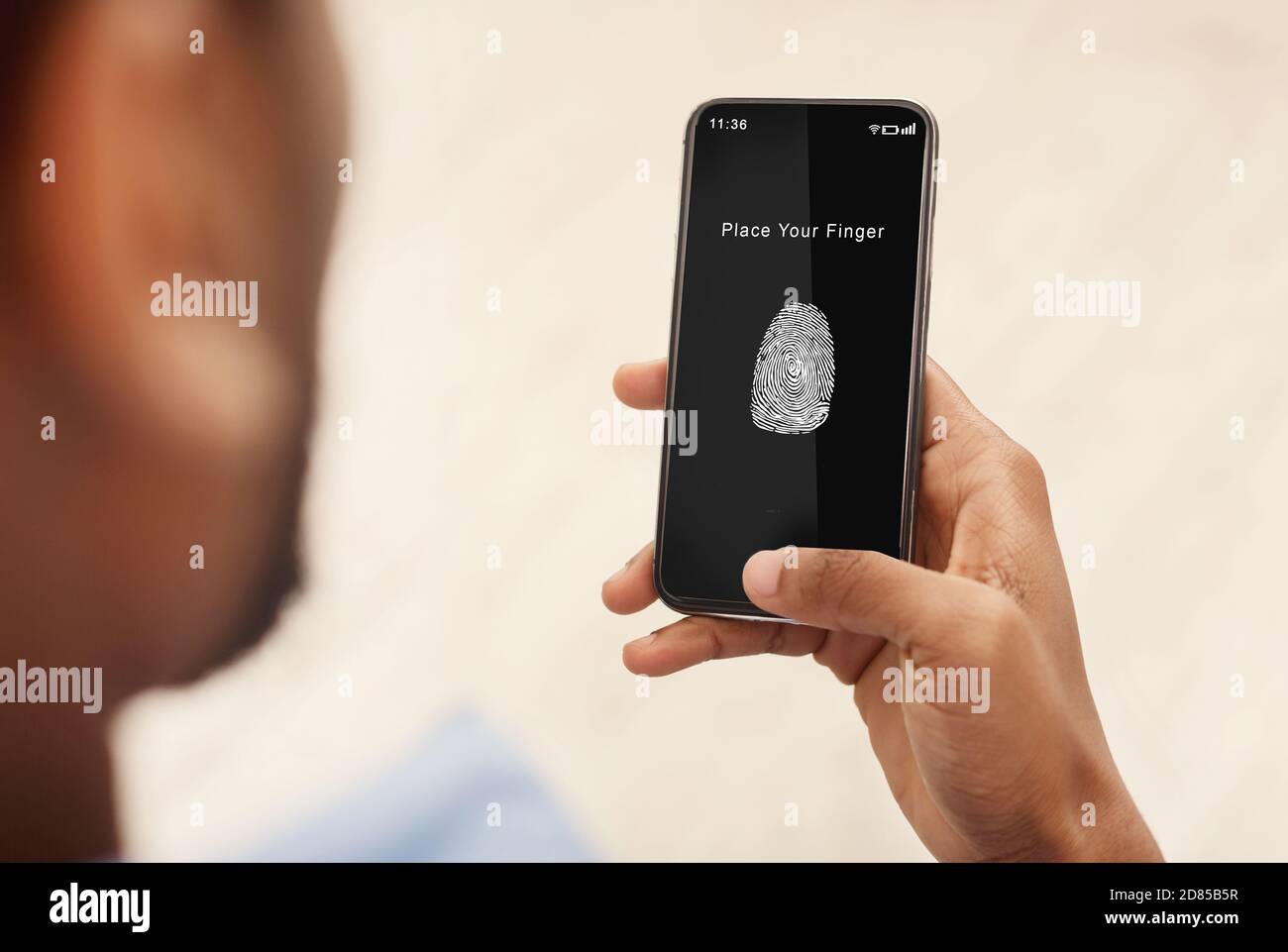 Man holding phone with fingerprint scanning app Stock Photo - Alamy