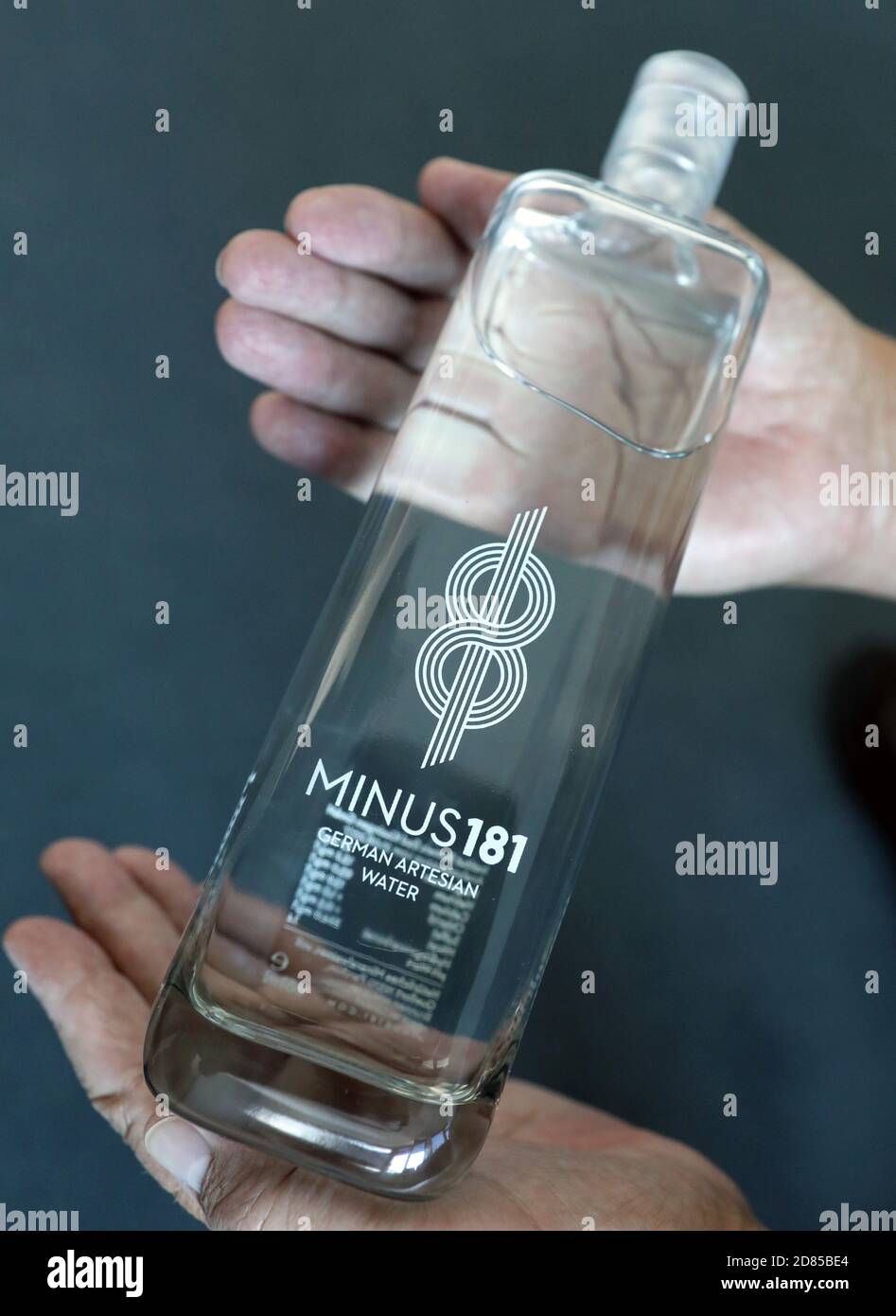 27 October 2020, Mecklenburg-Western Pomerania, Rostock: A man holds a  bottle of luxury mineral water of the brand 