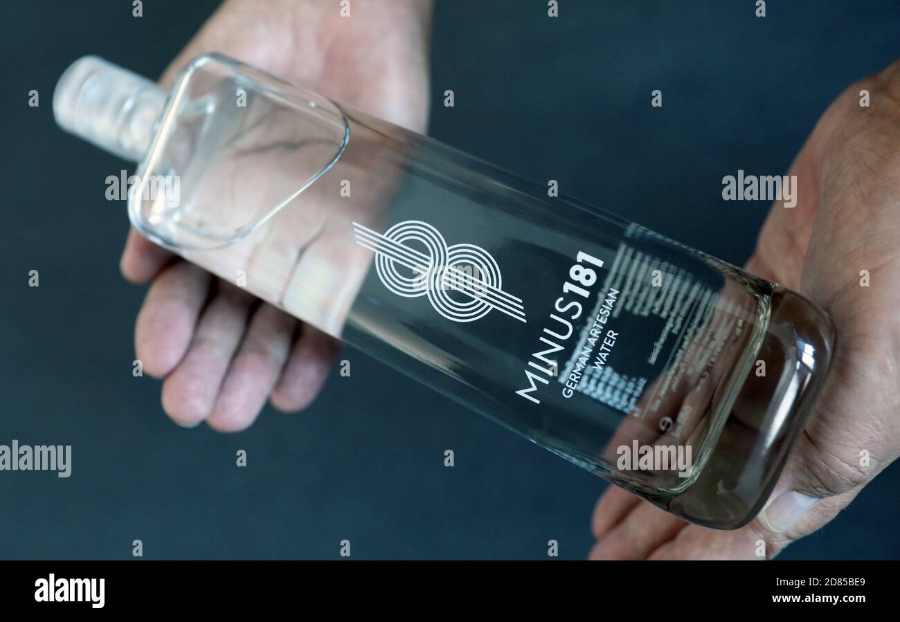 27 October 2020, Mecklenburg-Western Pomerania, Rostock: A man holds a  bottle of luxury mineral water of the brand 