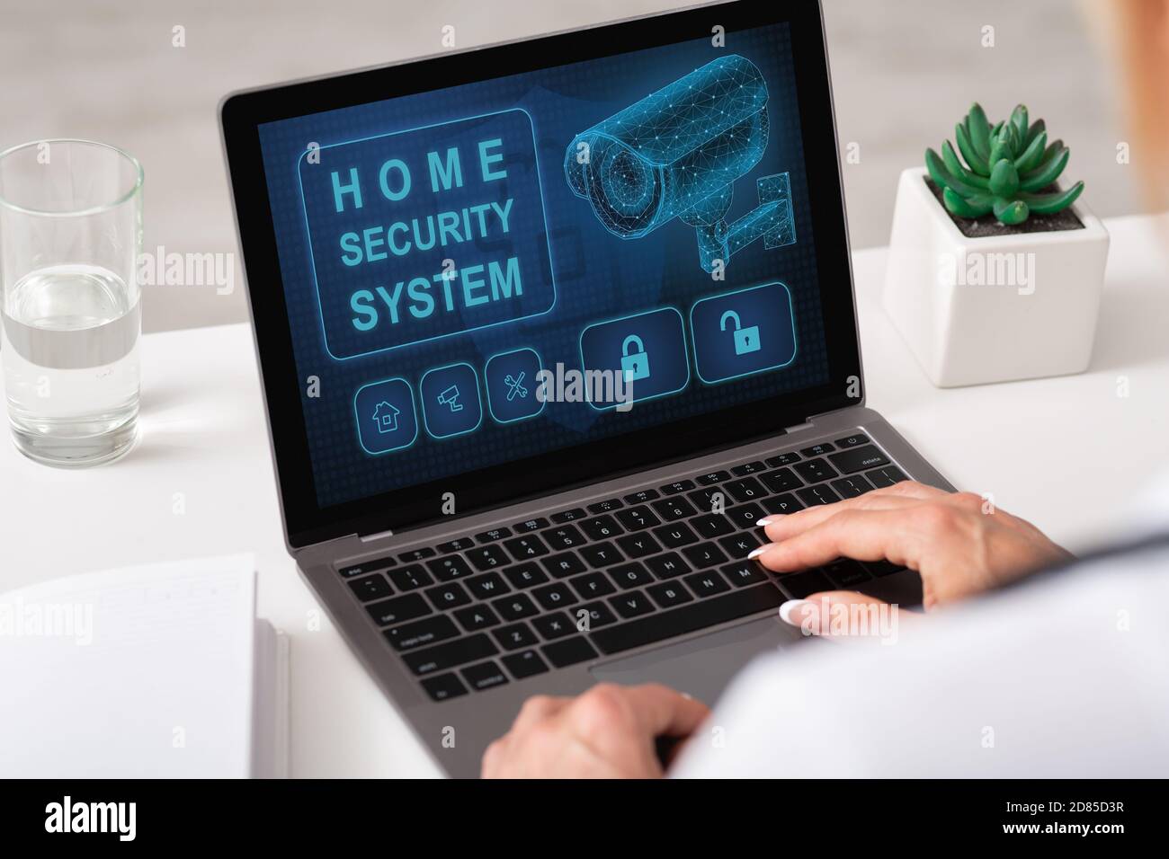 Woman using laptop with home security application Stock Photo