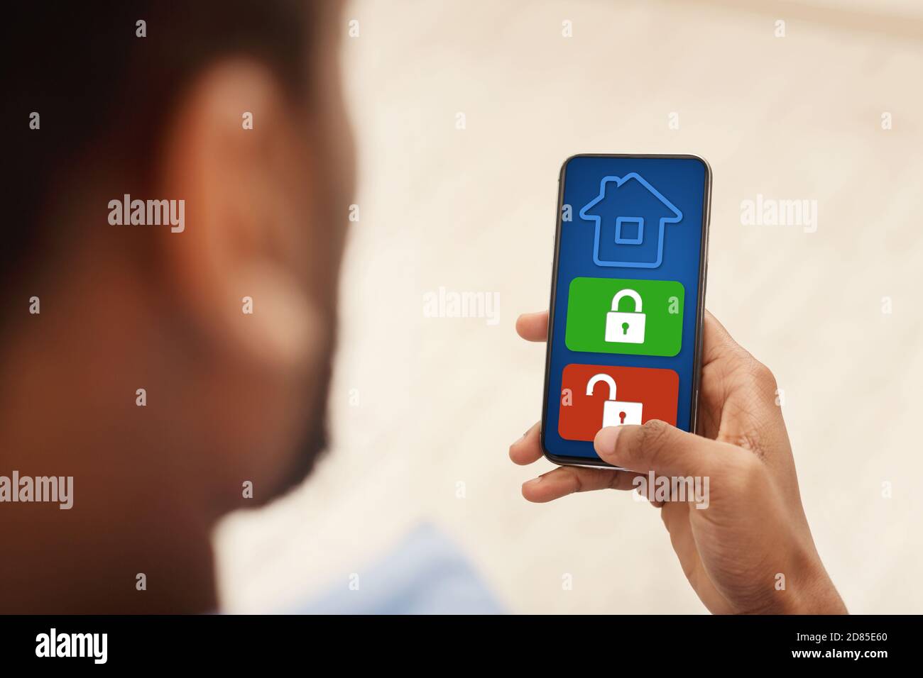 Man using his smartphone with home security application Stock Photo