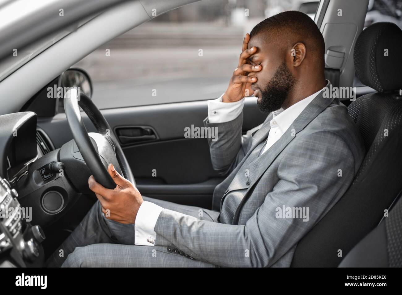Black businessman having troubles at work, sitting in car Stock Photo
