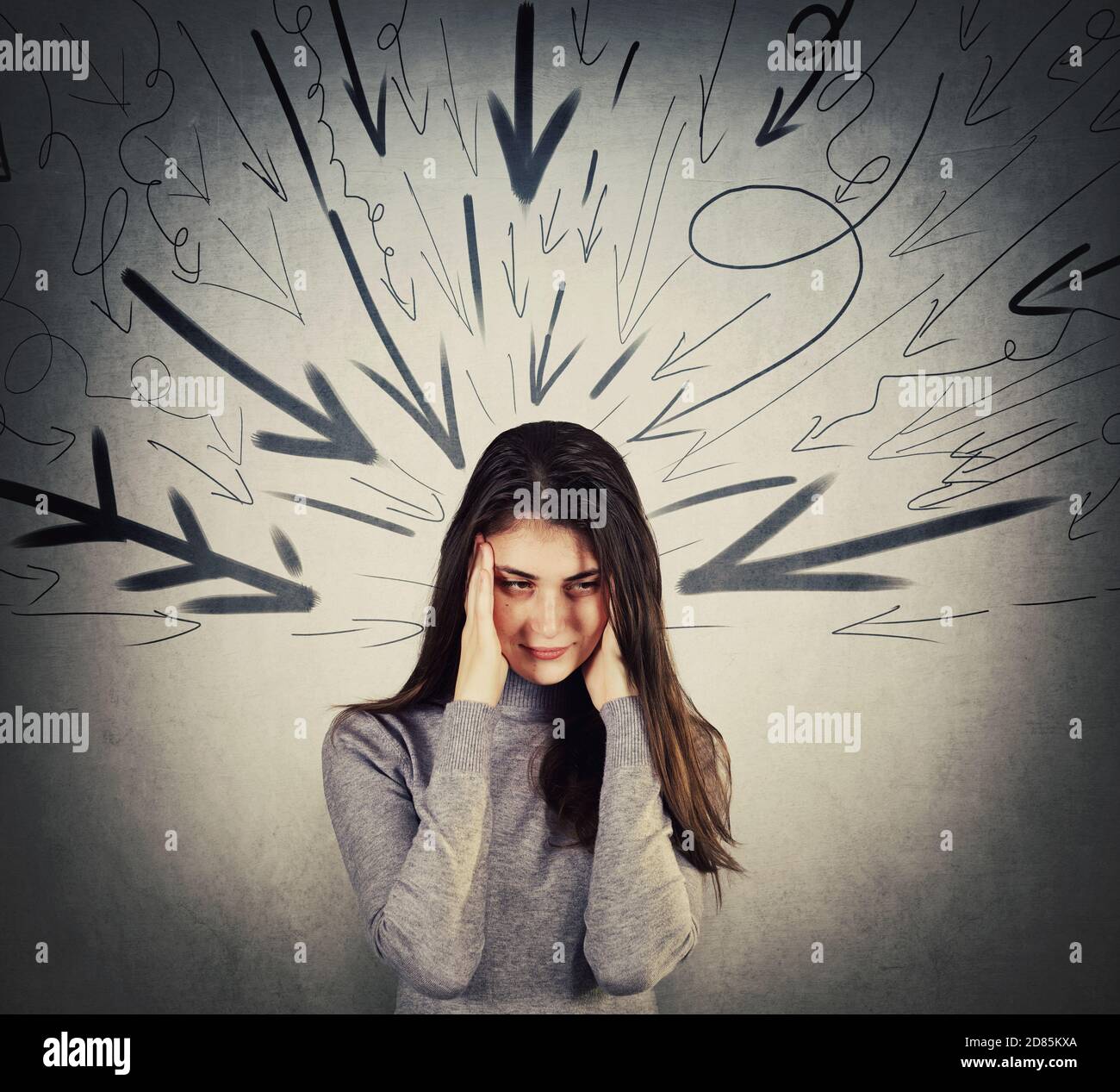 Irritated young woman covering ears with hands, looks displeased, refuse to listen. Teenager girl being under pressure as multiple arrows points negat Stock Photo