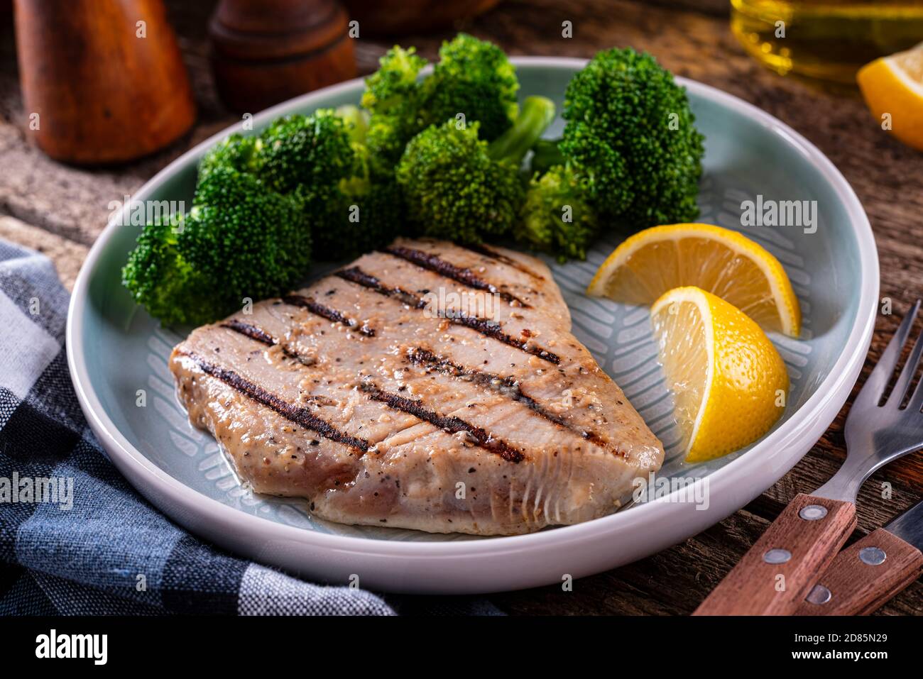 A delicious grilled lemon and pepper marinated tuna steak with steamed broccoli. Stock Photo