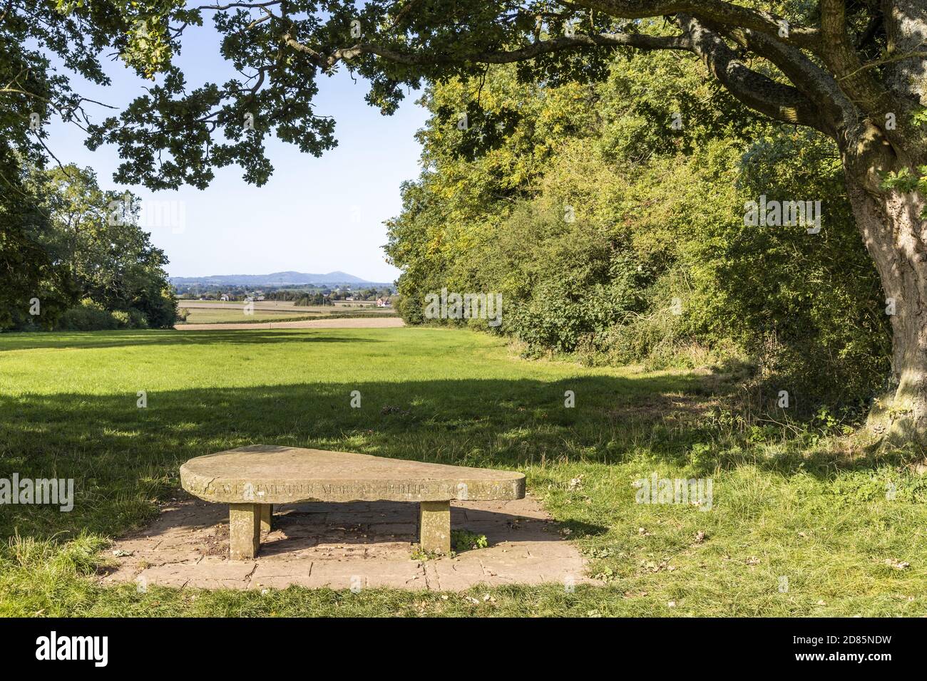 A stone memorial seat to Morgan Philips Price (1885 - 1973) at Demesne Wood near Bulley, Gloucestershire UK Stock Photo