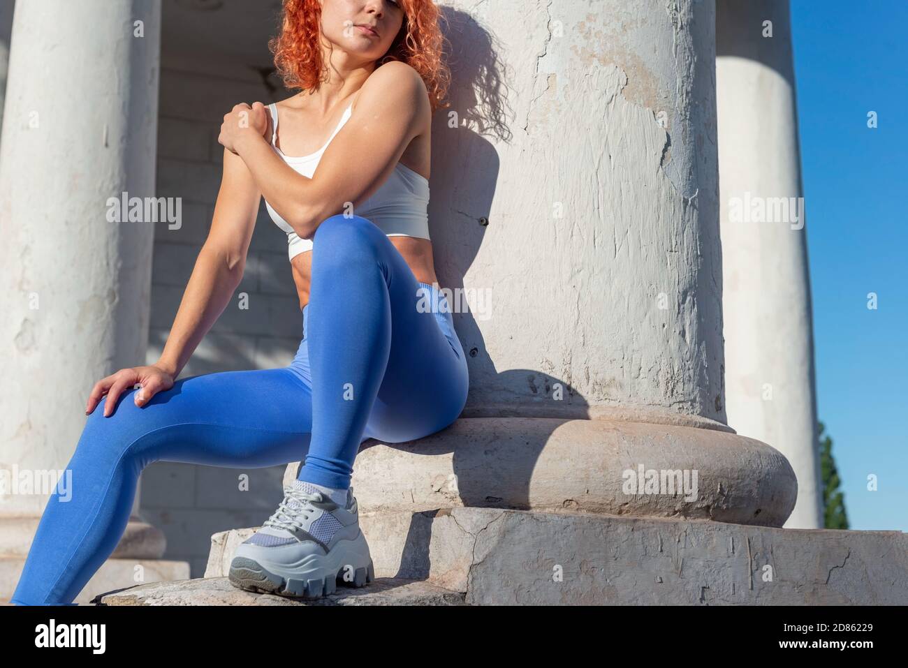 red-haired woman athlete, thirty-six years old, in sports leggings