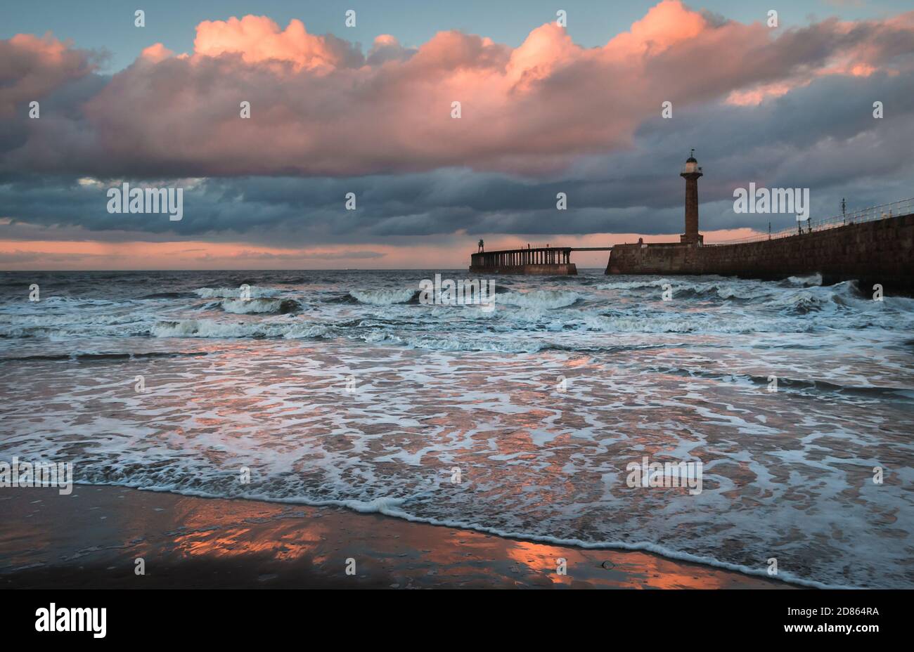 Pier at Whitby, North Yorkshire fishing port and historic seaside town on the River Esk. Dramatic evening light and stormy seas Stock Photo