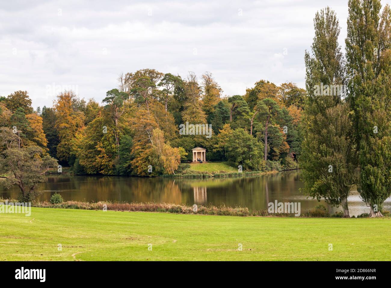 The Doric Temple folly reflected in the lake during autumn at Bowood ...