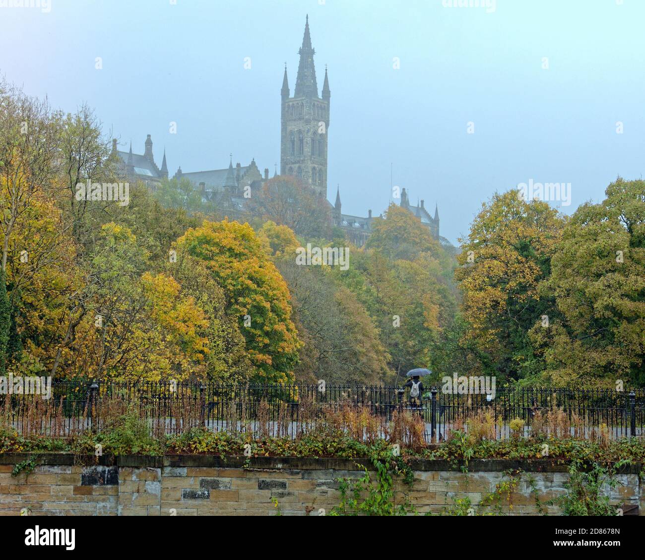 Glasgow, Scotland, UK. 27th October, 2020: UK Weather: Grey cold day saw rain amidst the umbrellas and masks the new sign of the times in the pandemic city life. Om partick bridge at the university og glasgow. Credit: Gerard Ferry/Alamy Live News Stock Photo